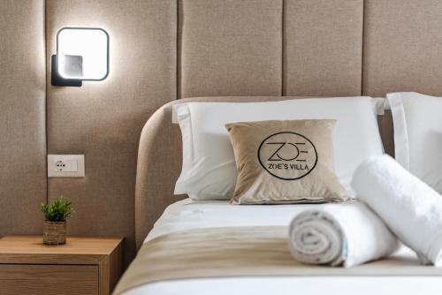 a bed with a pillow with a sign on it at Zoe's Villa by PS in Durrës