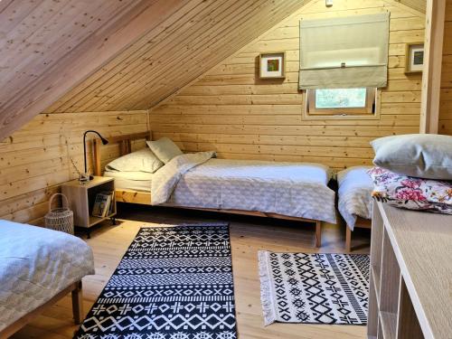 a bedroom with two beds in a log cabin at Sosny i Róże in Domysłów