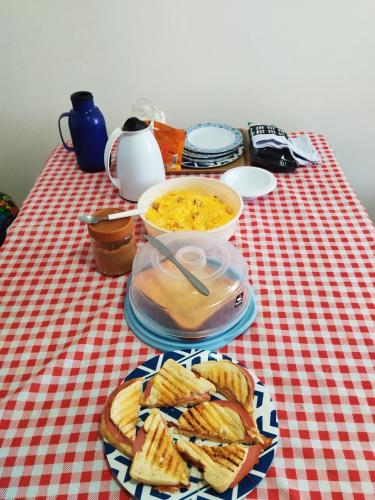 Una mesa con un plato de sándwiches y un tazón de comida. en quarto temporada são joão familiar até 4 pessoas, en Campina Grande