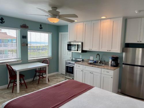 a kitchen with white cabinets and a table with a sink at Beachgate Condo Suites and Hotel 232 condo in Port Aransas