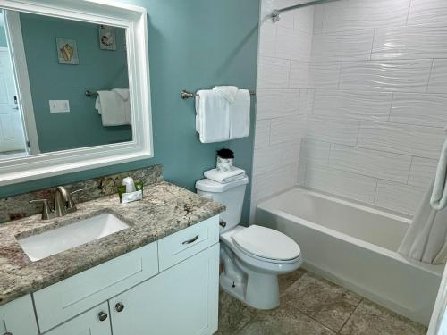 a bathroom with a toilet and a tub and a sink at Beachgate Condo Suites and Hotel 232 condo in Port Aransas