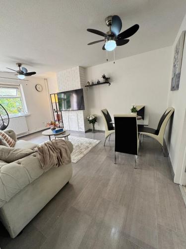 a living room with a couch and a ceiling fan at Swanky3Bed HomeModern Kitchen in Dudley