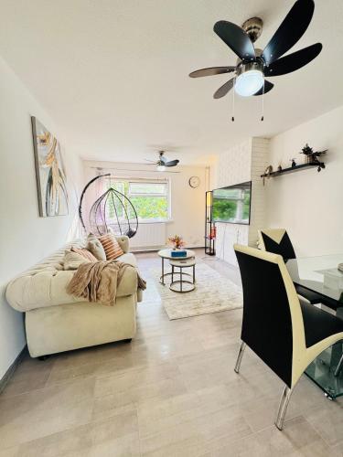 a living room with a couch and a ceiling fan at Swanky3Bed HomeModern Kitchen in Dudley