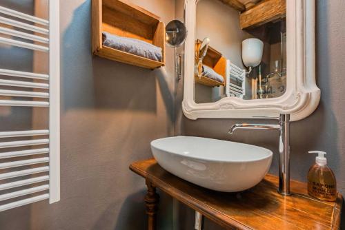 a bathroom with a white sink and a mirror at B&B Podere Camaiano in Roccastrada