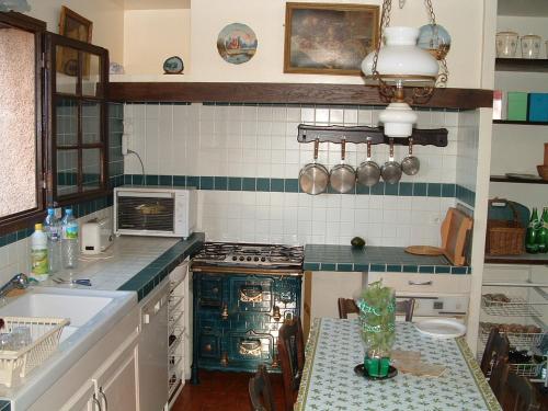 Il comprend une cuisine équipée d'une cuisinière, d'un évier et d'une table. dans l'établissement Bagnols-en-Forêt, promo semaine du 26 juillet, pool et villa privative, 8 personne, très beau site, à Bagnols-en-Forêt