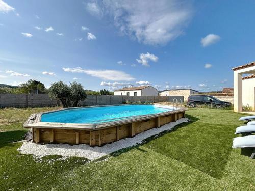 - une grande piscine dans une cour avec une voiture dans l'établissement Villa Grivia - Maison avec grand jardin - Piscine - Pétanque - Ping Pong, à Saint-André-de-Roquelongue