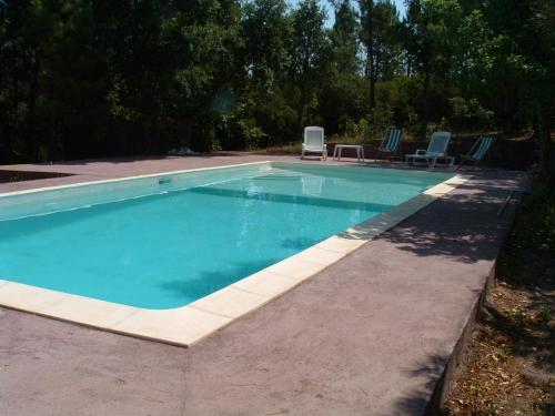 une piscine avec deux chaises et une table dans l'établissement Bagnols-en-Forêt, promo semaine du 26 juillet, pool et villa privative, 8 personne, très beau site, à Bagnols-en-Forêt