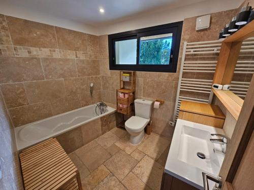 une salle de bain avec une baignoire, des toilettes et un lavabo dans l'établissement Jolie Villa spacieuse, à Saint-Clément-de-Rivière
