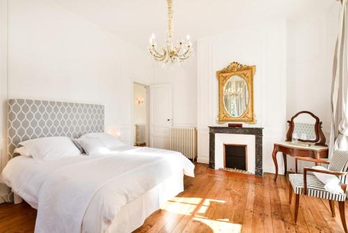- une chambre avec un lit, une cheminée et un lustre dans l'établissement Belle demeure XIXè au coeur des vignes, à Cambes