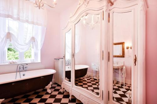 une salle de bain avec une baignoire et un grand miroir dans l'établissement Belle demeure XIXè au coeur des vignes, à Cambes