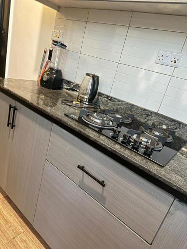 a kitchen counter with a stove top in a kitchen at Zaya Residency in Kampala