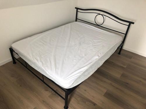 - un lit avec un cadre noir et des draps blancs dans l'établissement L'imperatrice, à Berck-sur-Mer