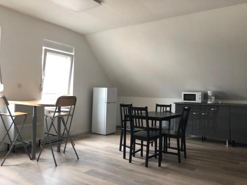 Cette chambre dispose d'une table, de chaises et d'un réfrigérateur. dans l'établissement L'imperatrice, à Berck-sur-Mer