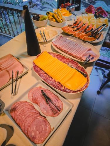 a table with different types of meats and cheese at Pousada Conde Redondo in Lumiar