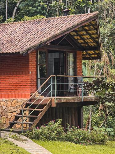 a small house with a porch and a deck at Pousada Conde Redondo in Lumiar