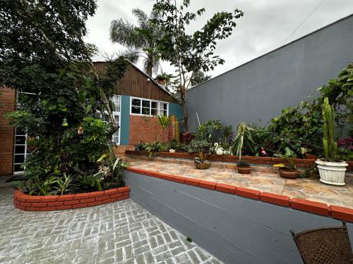 a garden with potted plants on the side of a building at Arthi - LINDO LOFT RECANTO DOS PASSARINHOS com HIDROMASSAGEM! in Balneário Camboriú