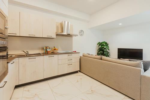 a living room with a couch and a kitchen at Luma apartment - Sliema with Outdoor Space and BBQ Area in Sliema