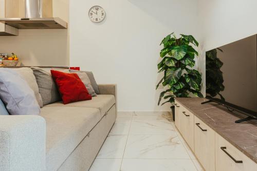 a living room with a couch and a plant at Luma apartment - Sliema with Outdoor Space and BBQ Area in Sliema