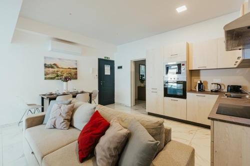a living room with a couch and a kitchen at Luma apartment - Sliema with Outdoor Space and BBQ Area in Sliema