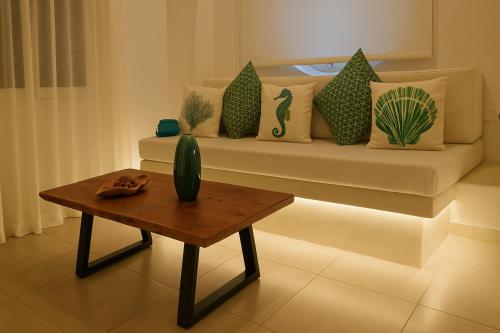 a living room with a couch with pillows and a table at Diana's Luxury Suites in Kithnos