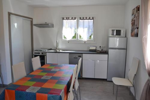 une cuisine avec une table et une nappe colorée. dans l'établissement Gite avec barbecue et terrasse clos, à Lagorce