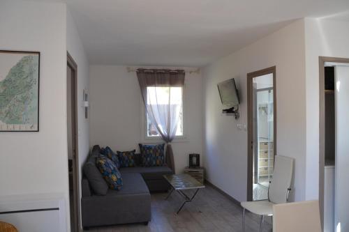 un salon avec un canapé et une fenêtre dans l'établissement Gite avec barbecue et terrasse clos, à Lagorce