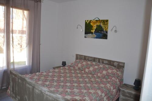 une chambre avec un lit avec une couette rouge dans l'établissement Gite avec barbecue et terrasse clos, à Lagorce