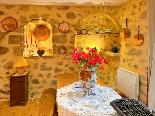 une chambre avec une table et un vase de fleurs dans l'établissement Maison de Village au cœur de Laroquebrou, à Laroquebrou