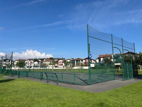 une cage de frappeur dans un parc avec de l'herbe et des maisons dans l'établissement Maison a Socoa, à Urrugne