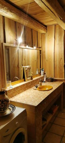 - un comptoir de cuisine avec un évier et un miroir dans l'établissement Maison de charme à la Salvetat-sur-Agout 3 chambres, à La Salvetat-sur-Agout