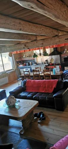 un salon avec un canapé en cuir noir et une table dans l'établissement Maison de charme à la Salvetat-sur-Agout 3 chambres, à La Salvetat-sur-Agout