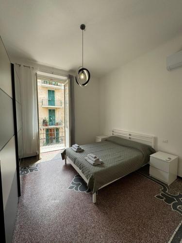 a bedroom with a bed and a large window at Savona Casa Centro vicino Mare in Savona