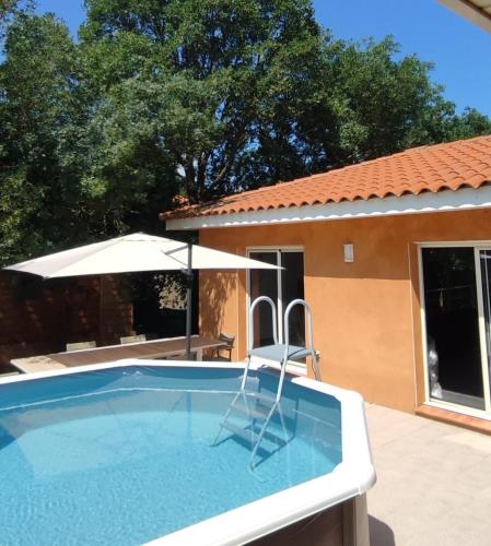 a pool with a chair and an umbrella at Villa vacances in Les Cluses