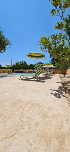 a park with picnic tables and a yellow umbrella at La Fontana Dei Desideri in Alghero