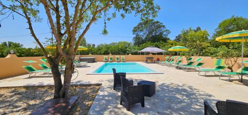 a swimming pool with lawn chairs and umbrellas at La Fontana Dei Desideri in Alghero