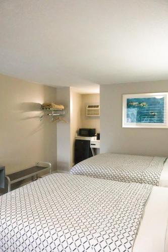 a bedroom with a white bed and a kitchen at Economy Inn Historic District in Saint Augustine