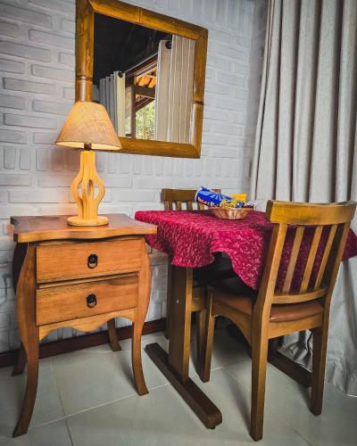 a table with a lamp and a table with a mirror at Pousada Conde Redondo in Lumiar