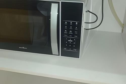 a microwave oven sitting on top of a counter at Apartamento do centro in Caxias do Sul