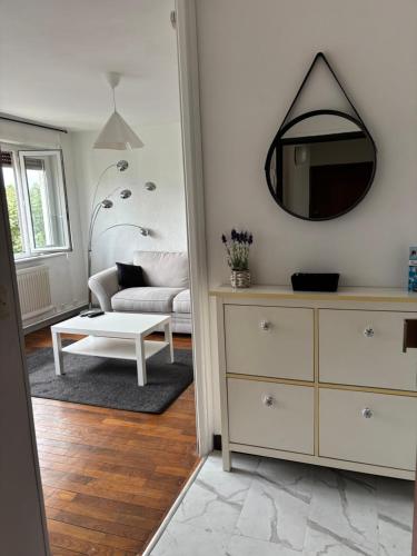 un salon avec un canapé et un miroir dans l'établissement Appartement des merveilles, à Vénissieux