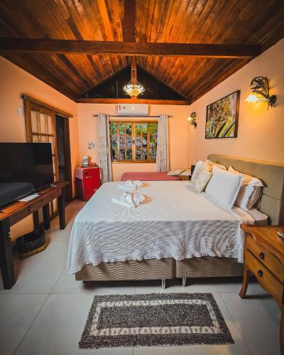 a bedroom with a large bed and a piano at Pousada Conde Redondo in Lumiar