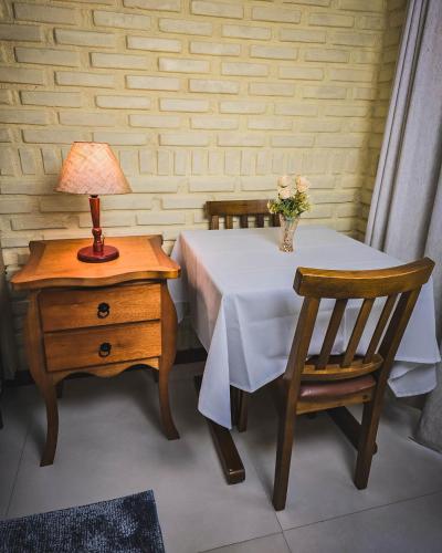 a table with a vase of flowers and a lamp on a side table at Pousada Conde Redondo in Lumiar
