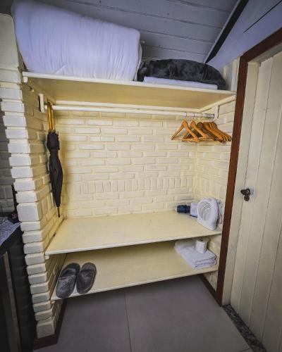a small room with a bed and shoes in it at Pousada Conde Redondo in Lumiar