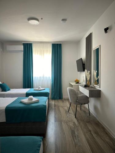 a hotel room with two beds and a chair at Hotel Mondo in Budva