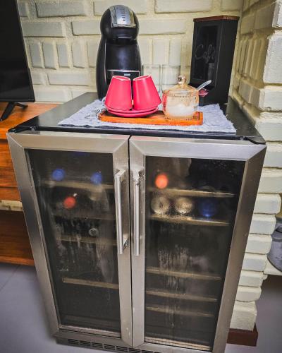 a microwave oven with red dishes on top of it at Pousada Conde Redondo in Lumiar