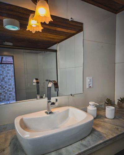 a sink in a bathroom with a large mirror at Pousada Conde Redondo in Lumiar
