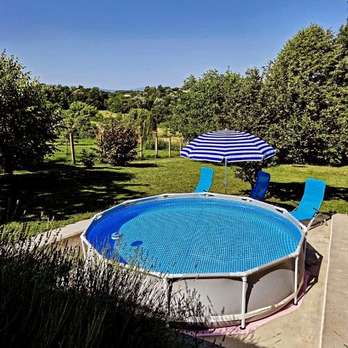 a swimming pool with two chairs and an umbrella at Seosko turističko domaćinstvo "Klinačka priča" in Valjevo