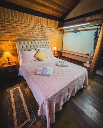 a bedroom with a large bed with two towels on it at Pousada Conde Redondo in Lumiar