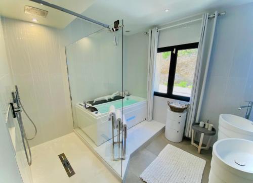 a bathroom with a glass shower and a toilet at Villa prestige au bord de l'eau- Pietracorbara in Pietracorbara