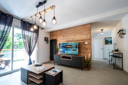 a living room with wooden walls and a flat screen tv at Appartement Neuf au pied Prorel in Briançon