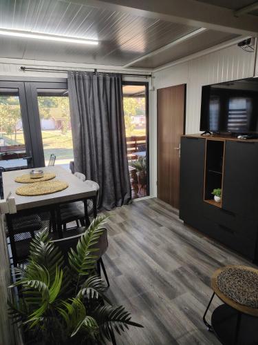 a living room with a table and a tv at Mobile home Amfora in Sveti Juraj
